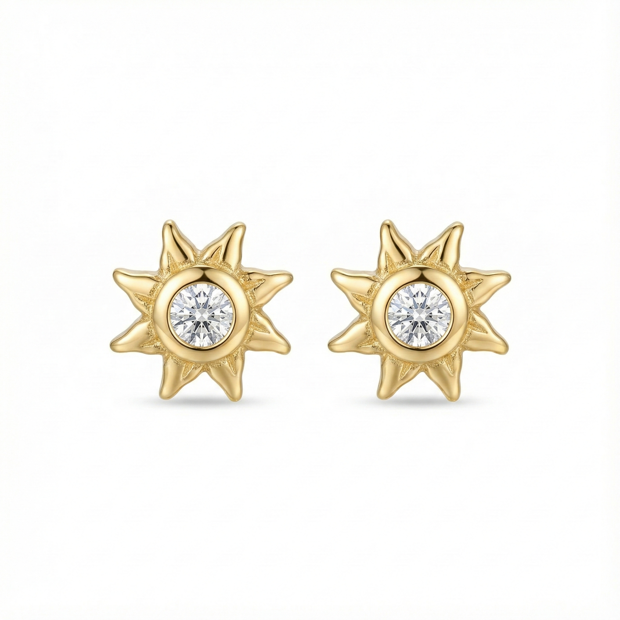 Boucles d'oreilles puces en forme de soleil en argent 925 doré à l'or fin, serties d'un zircon central brillant.
